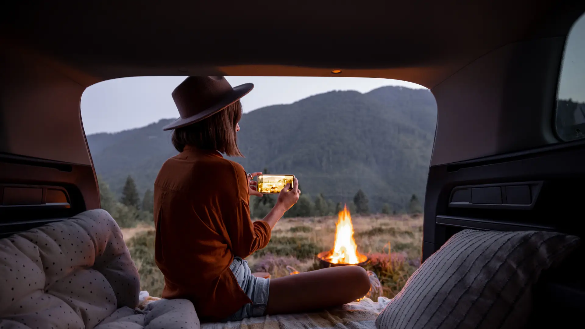 Happy tourist in a camper using her mobile with Giffgaff roaming fee