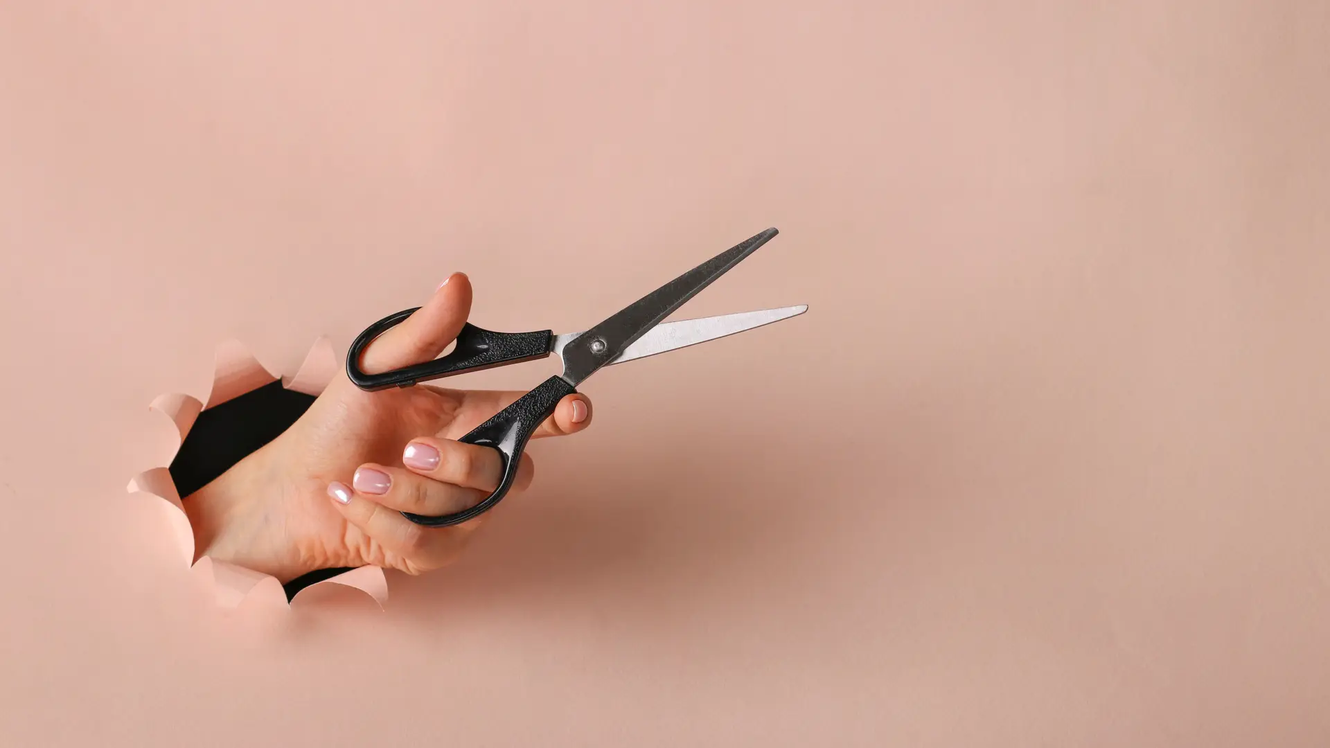 Hand holding a scissors that means how to cancell a phone contracts