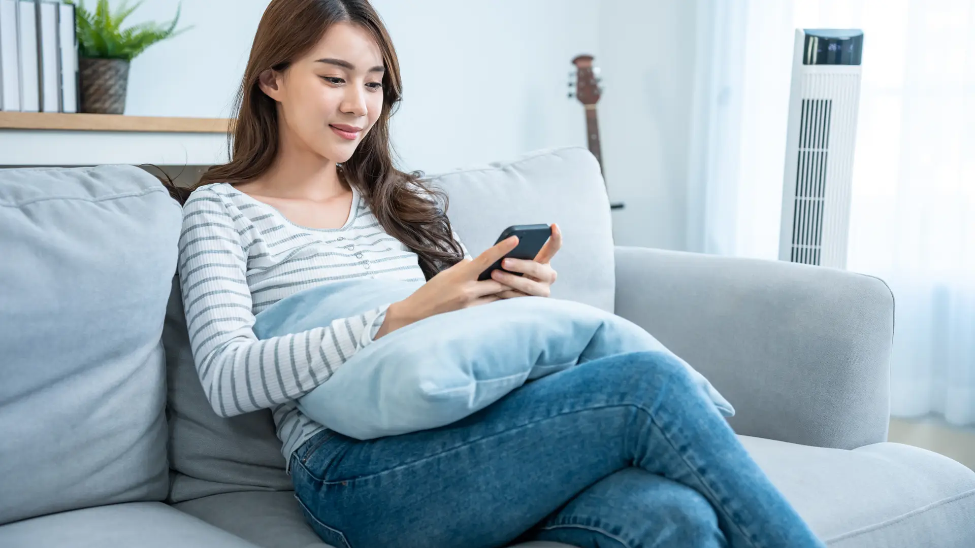 Young woman using her mobile phone for checking the Idmobile deals upgrades