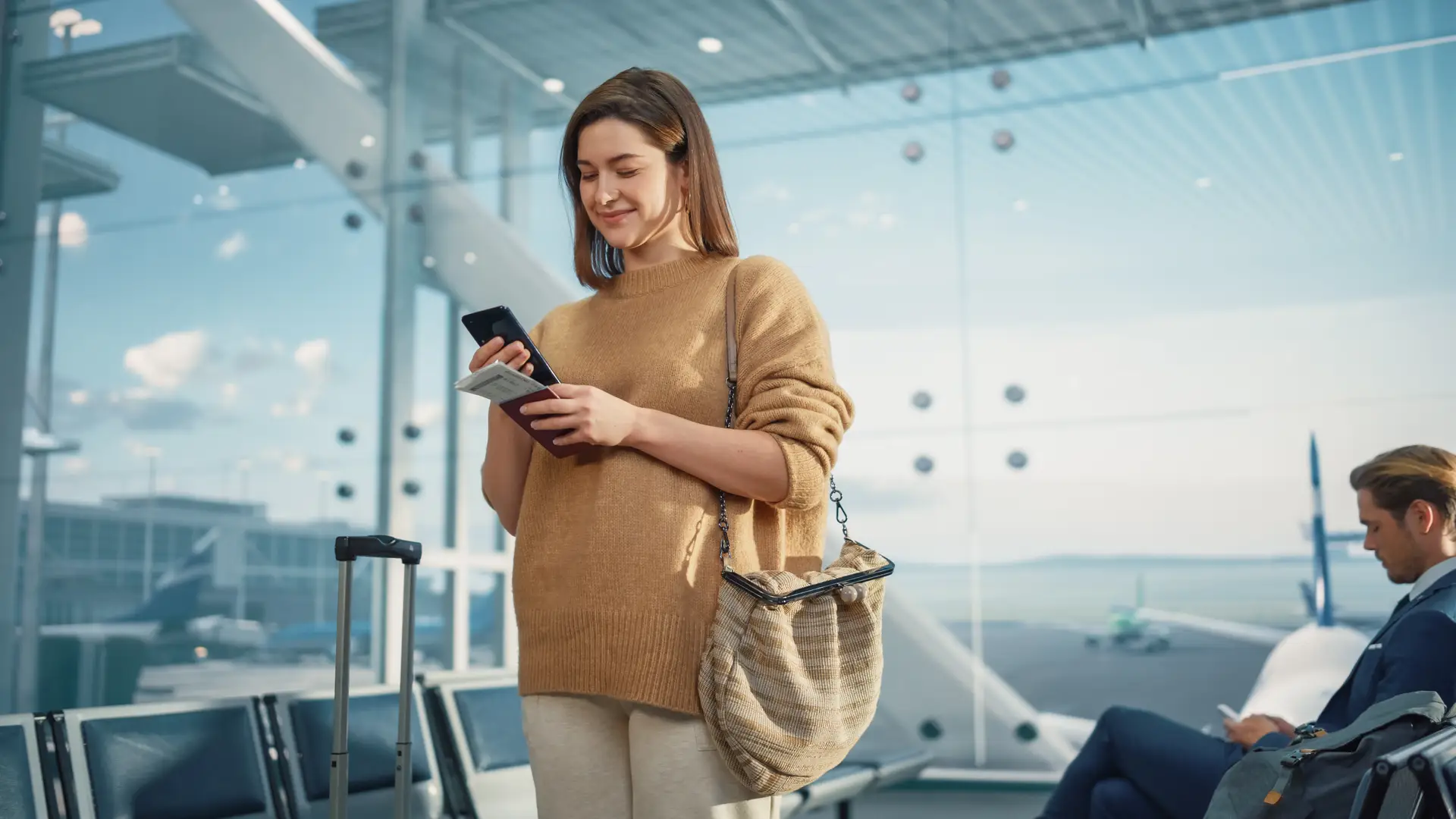 Women at the aiport cheking on her phone the IdMobile roaming plans