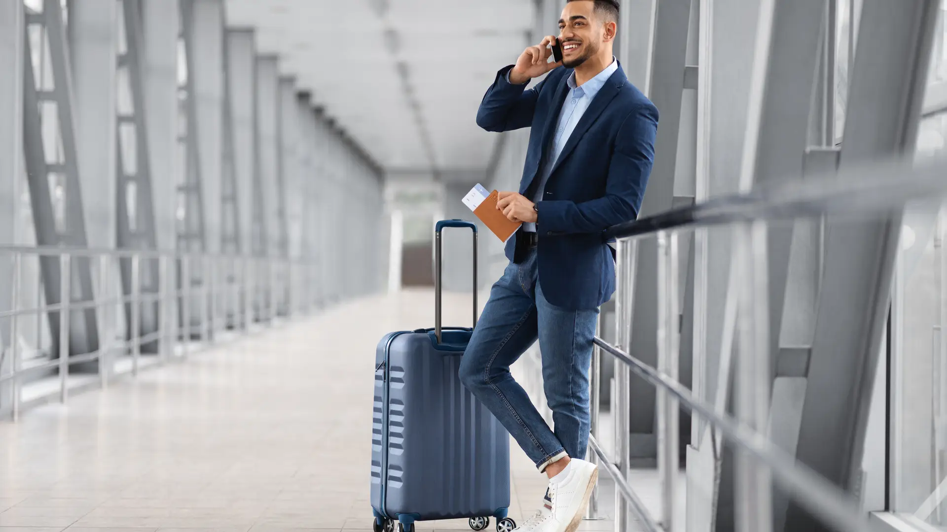 Young men talking on his phone at the airport because he has hired a Lebara roaming plan