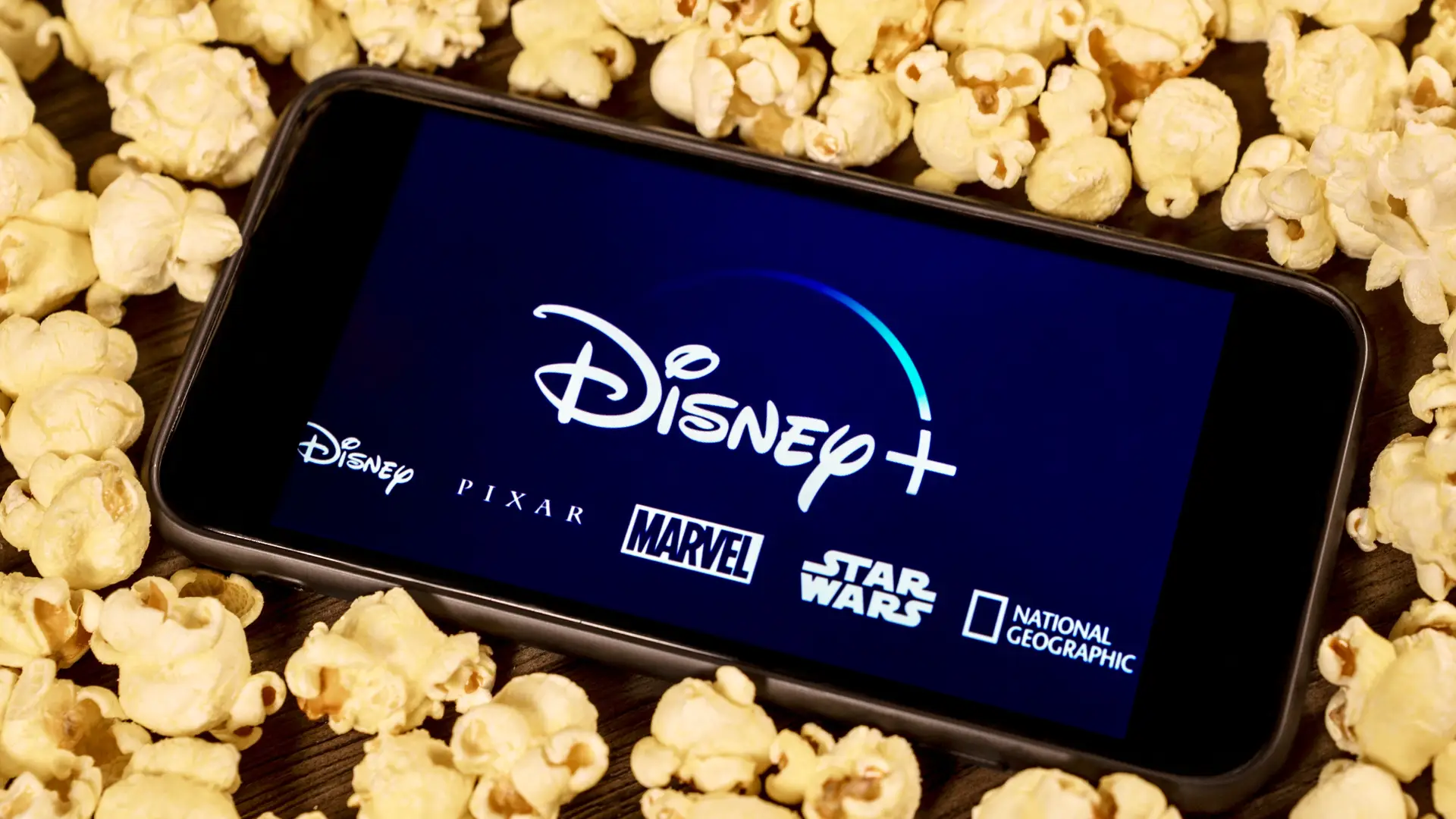 Disney plus logo on a smartphone with popcorn that you can enjoy with the provider sky