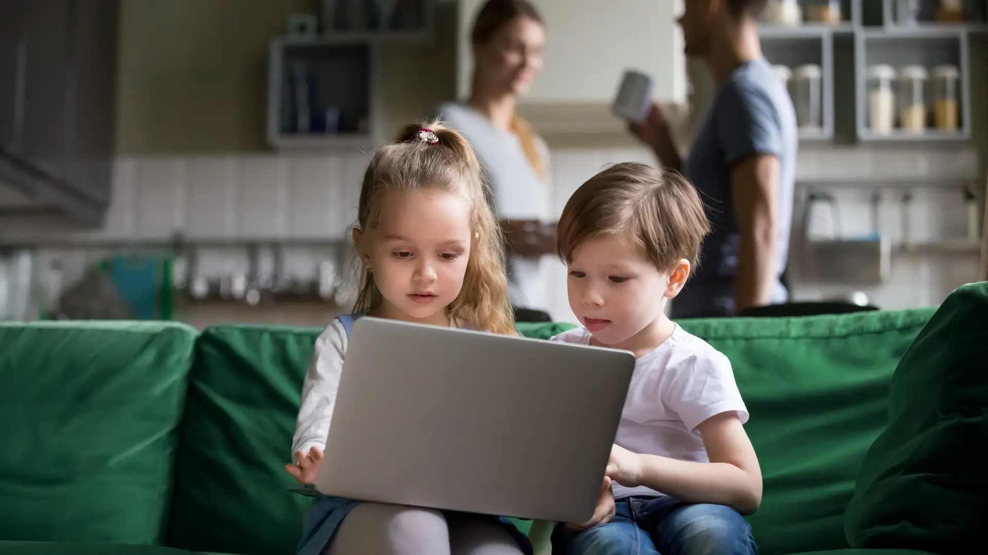 Two kids usign a laptop becauase they have a Virginmedia parental control