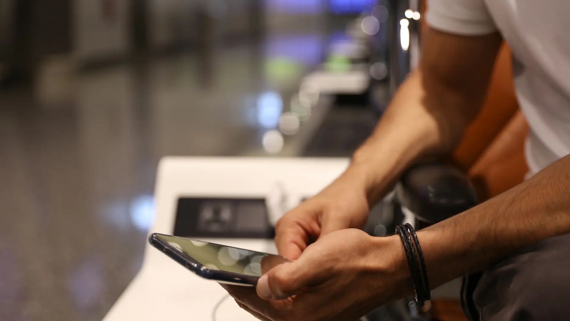 Men at the airport checking on her phone Voxi roaming plans